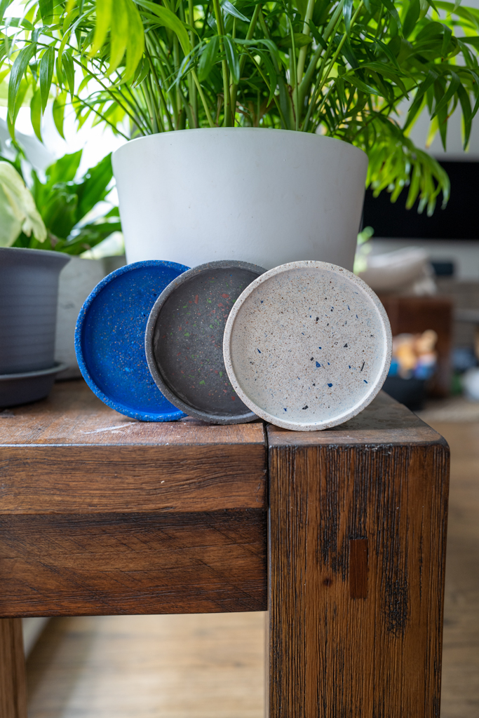 Blue, grey, and white terrazzo coasters on top of a wooden bench